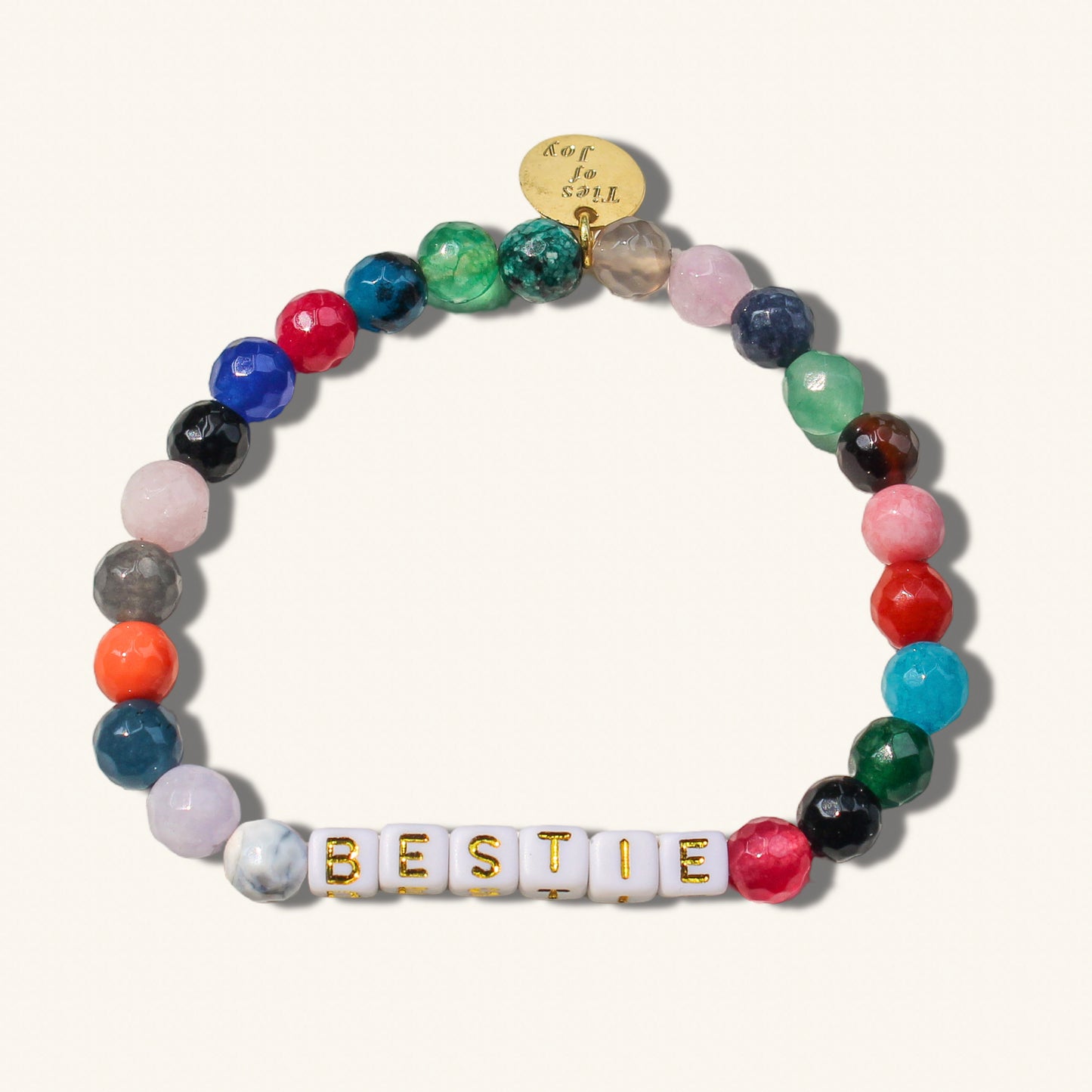 Multicolored beaded bracelet with 'BESTIE' charm on a white background