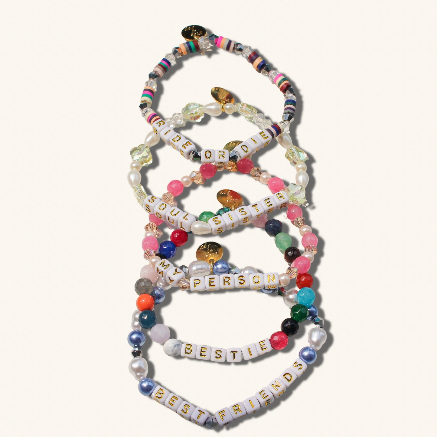 Set of colorful beaded bracelets with letter beads on a white background