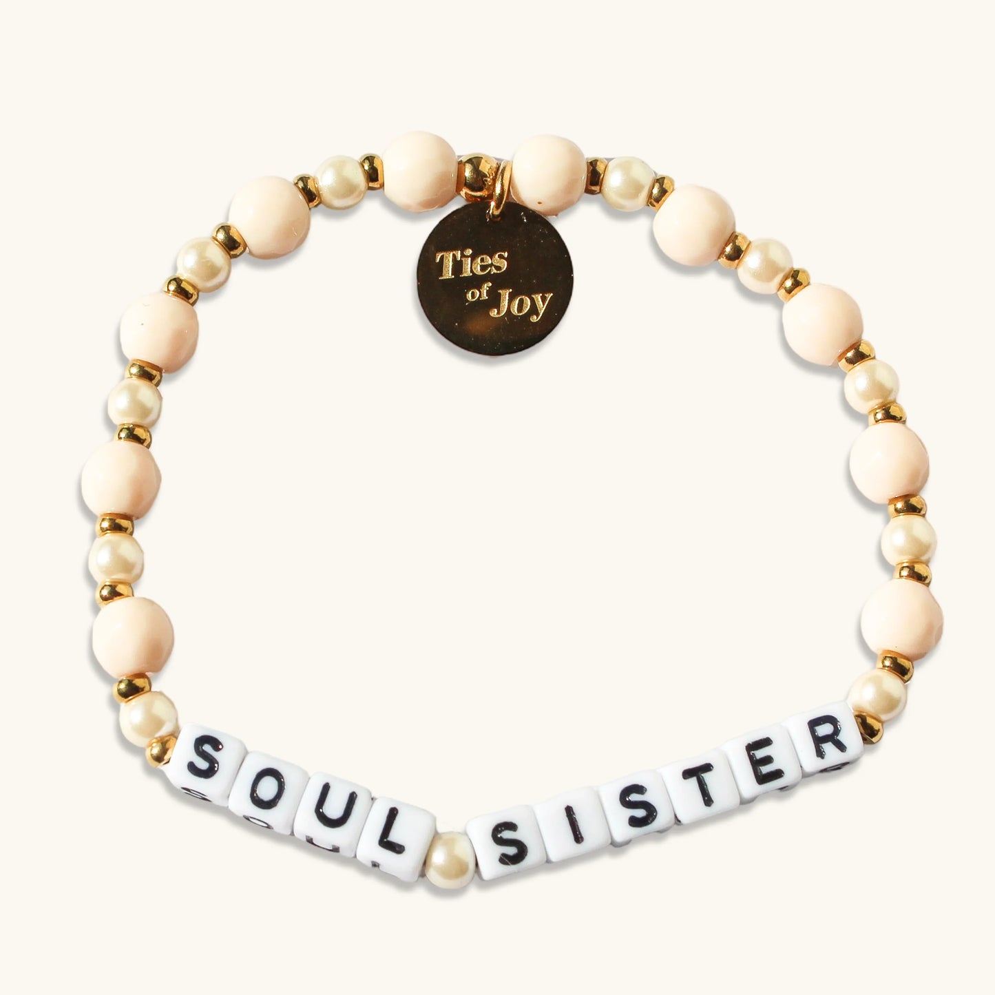Soul Sister beaded bracelet with gold Ties of Joy charm on a cream background