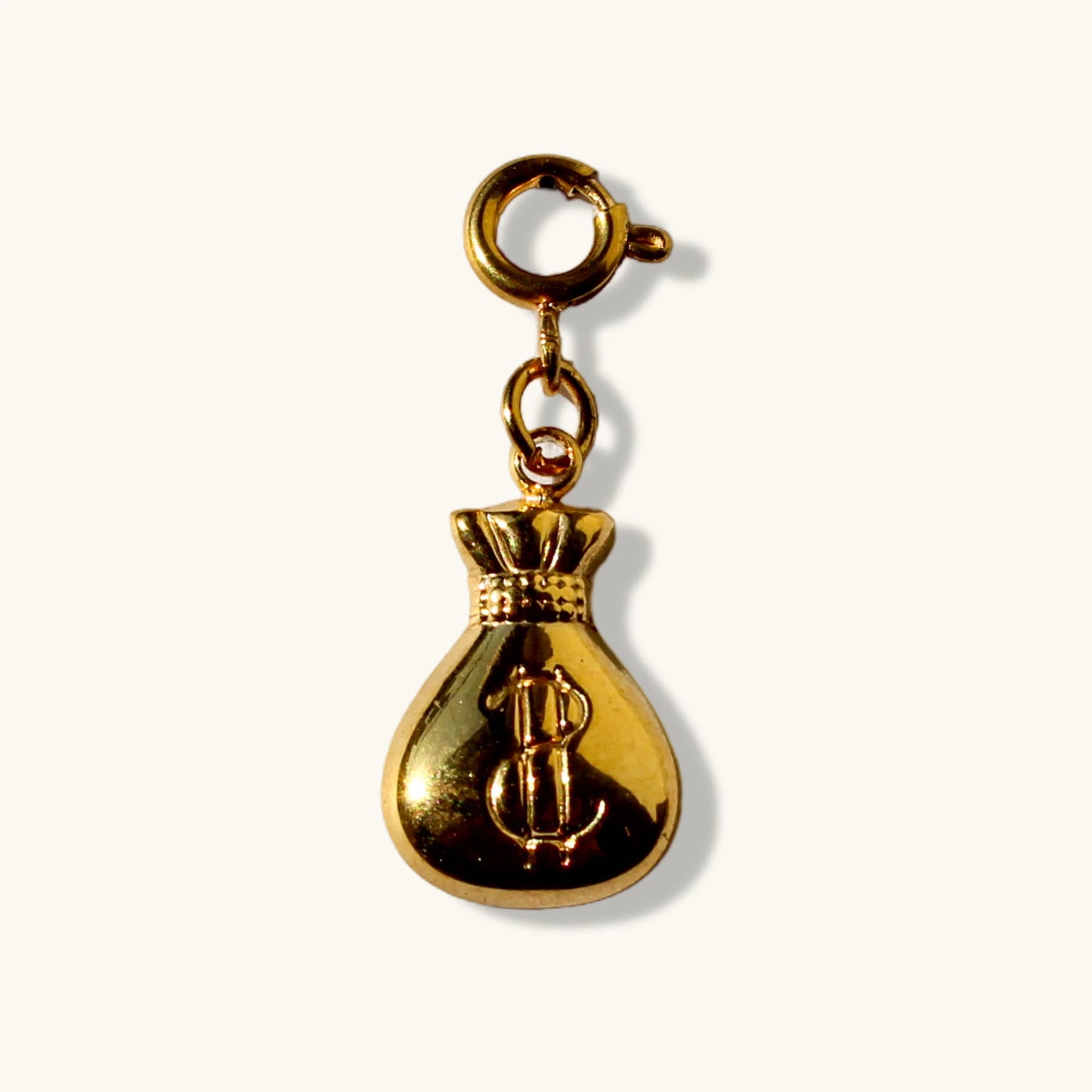 Gold money bag charm pendant with dollar sign on white background