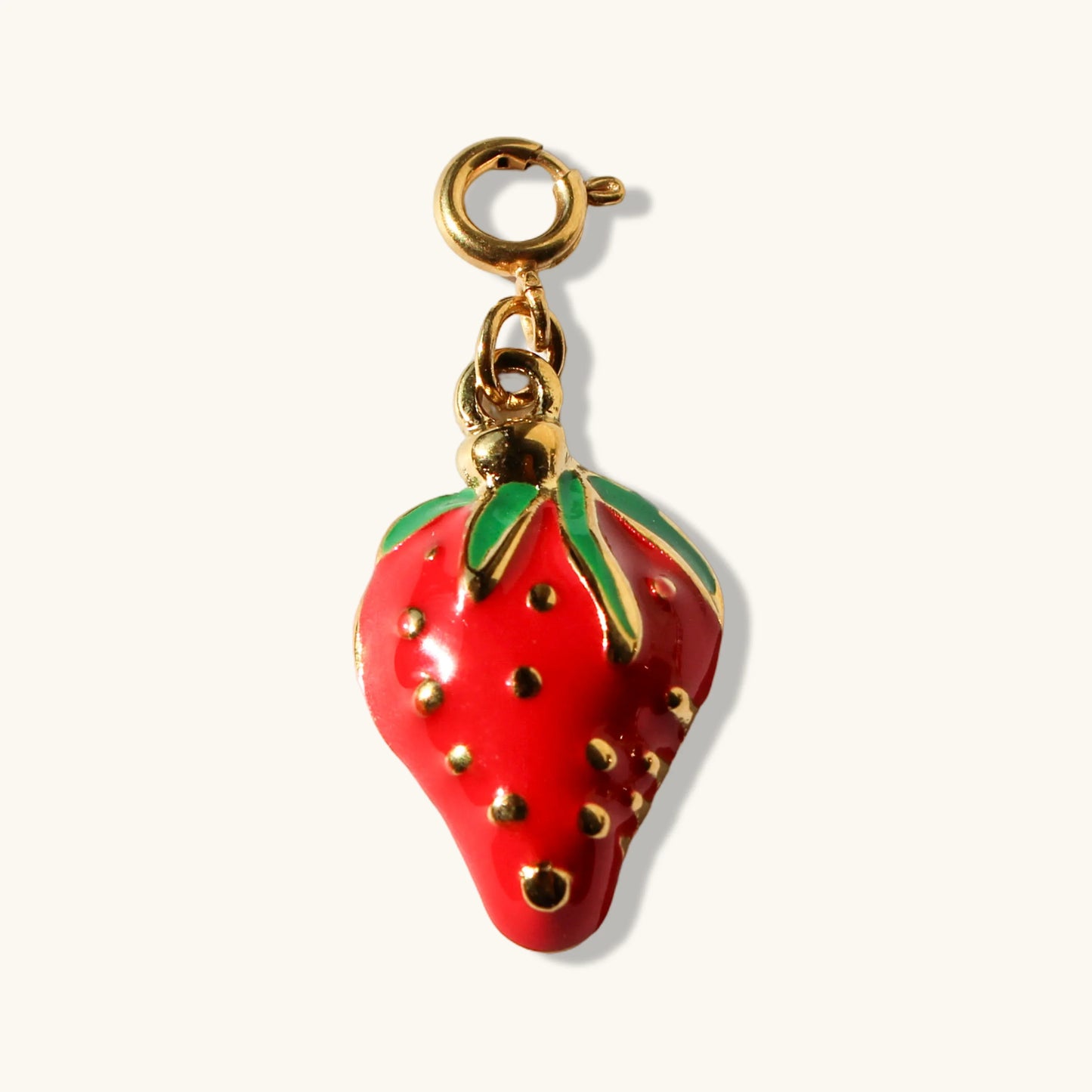 Red strawberry charm pendant with gold hardware on a white background