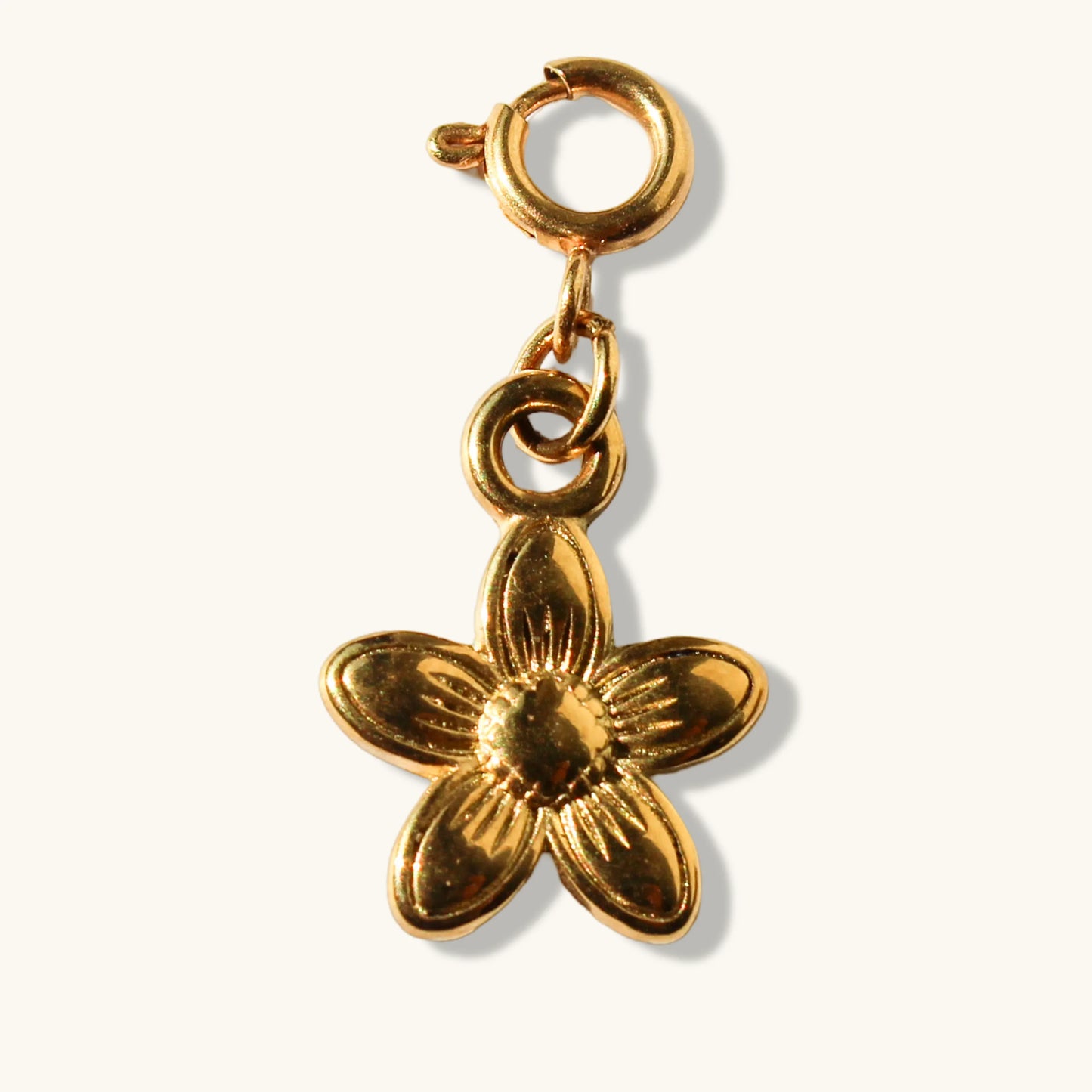 Gold flower charm pendant with lobster clasp on white background