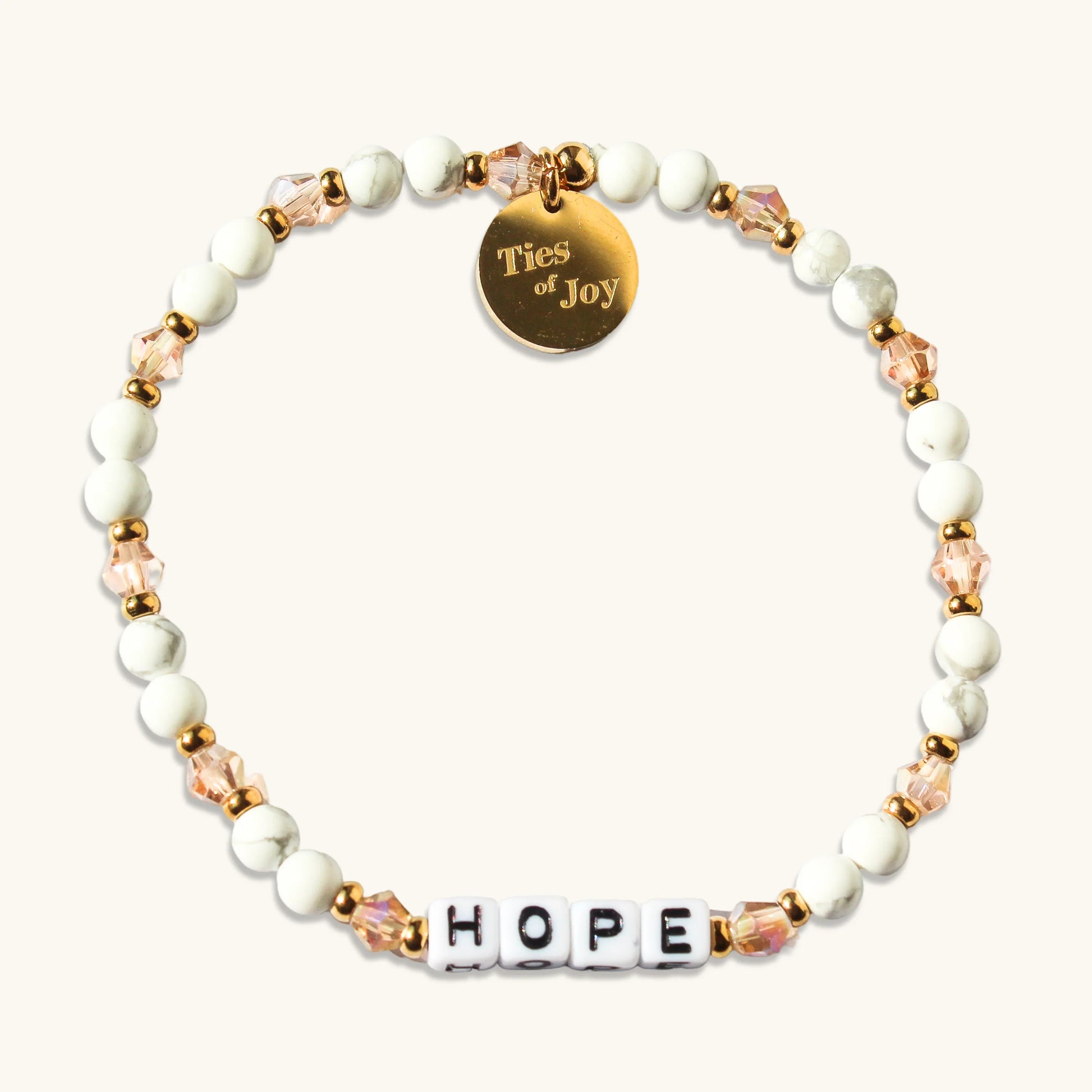 Hope beaded bracelet with white and gold beads, pink crystals, and Ties of Joy charm