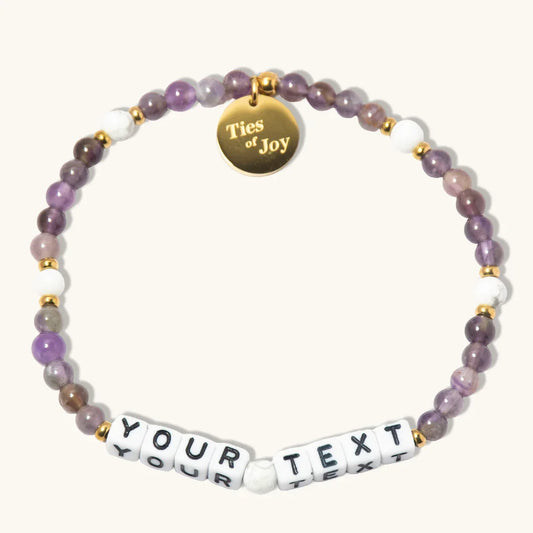 Custom beaded bracelet with purple stones, gold charm reading 'Ties of Joy', and YOUR TEXT beads