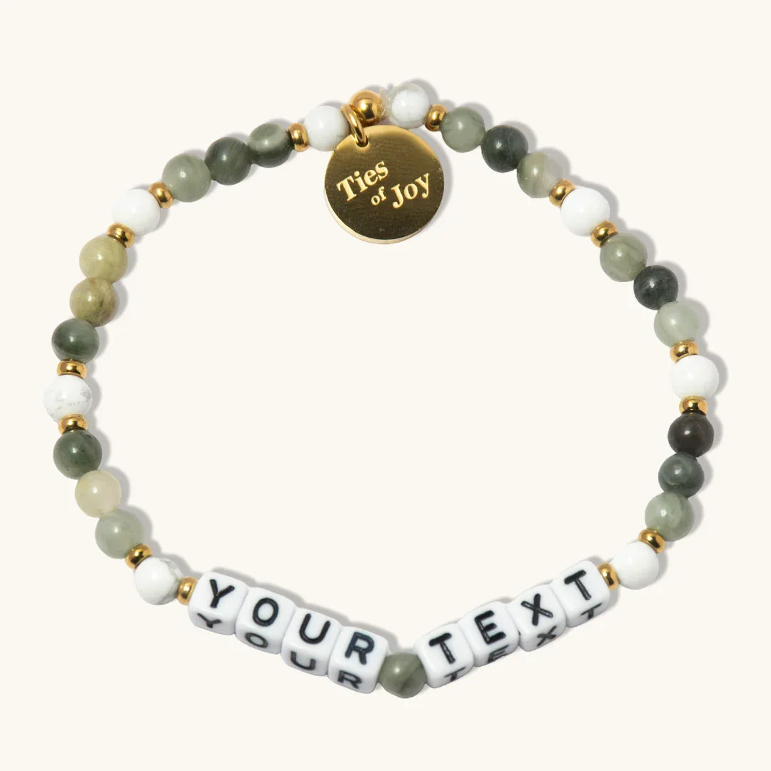 Custom beaded bracelet with green, white, gold beads and 'Ties of Joy' charm