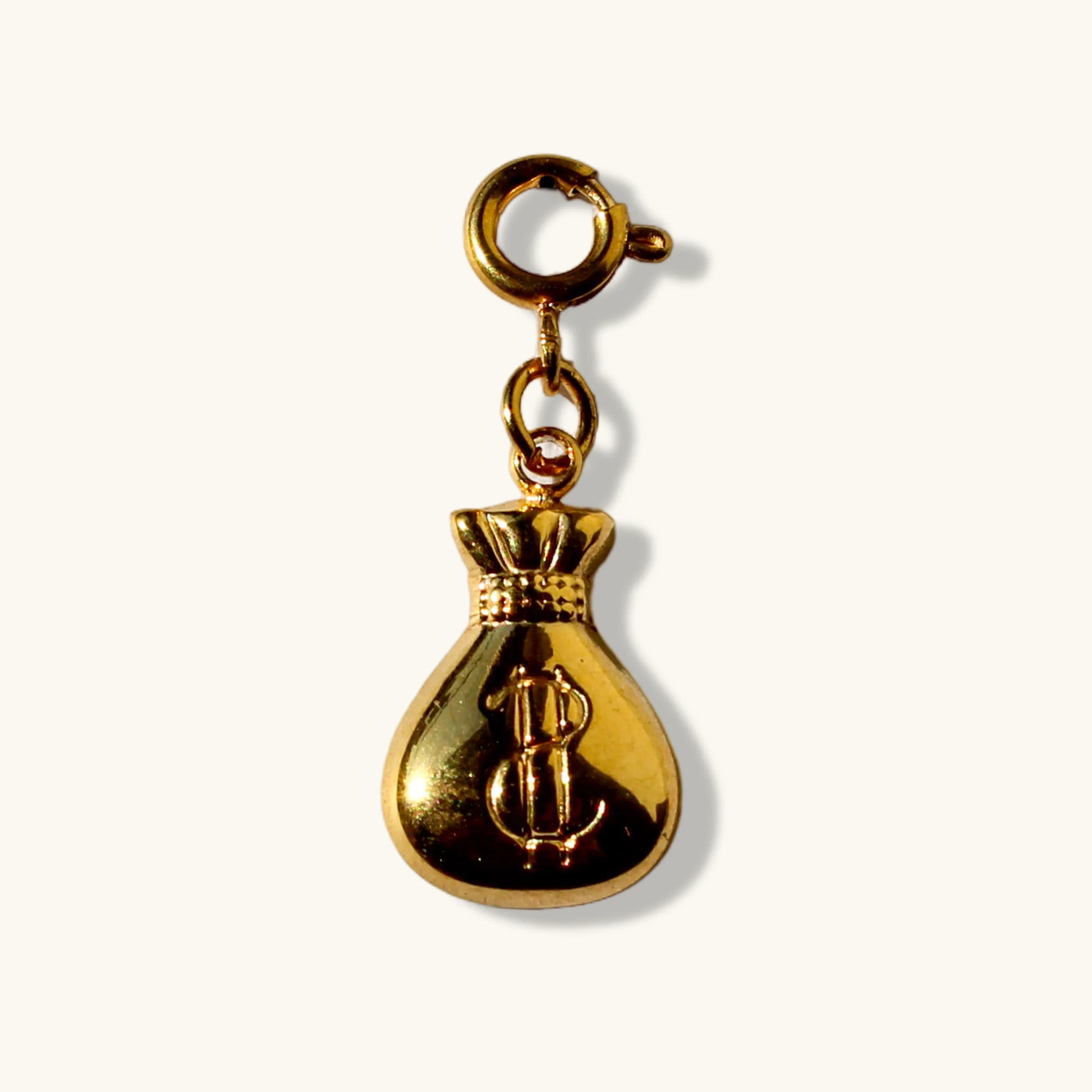 Gold money bag charm pendant with dollar sign on white background