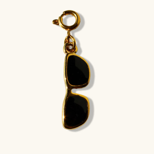 Gold sunglasses charm with black enamel pendant on a white background