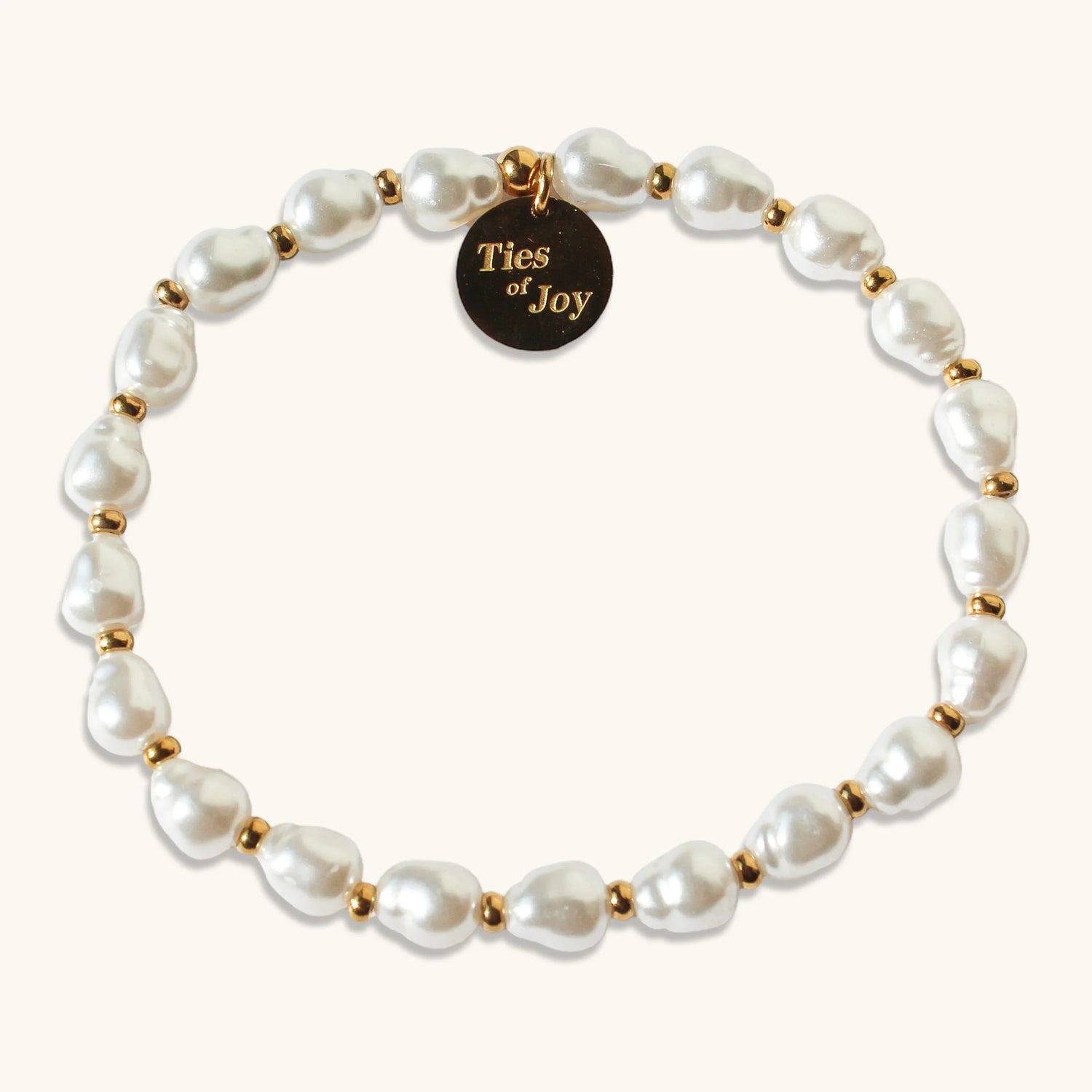Pearl beaded bracelet with gold accents and Ties of Joy round charm on a light background