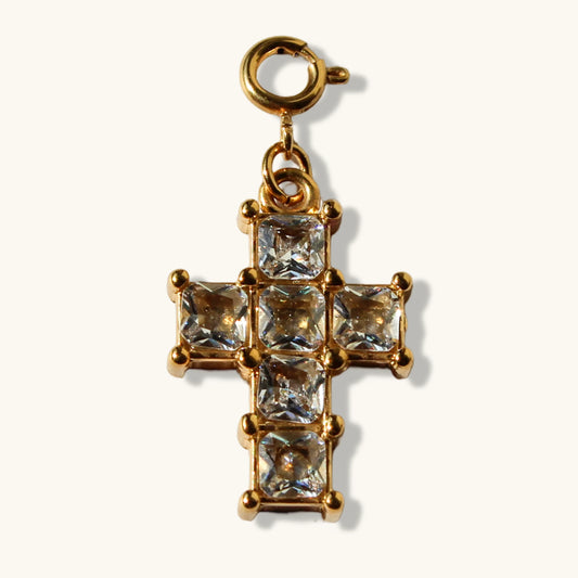 Gold cross pendant with square clear crystals on cream background