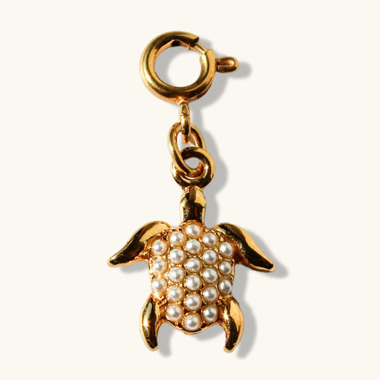 Gold turtle pendant charm with pearl accents on cream background