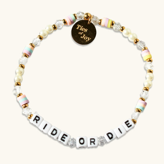 Beaded bracelet with pastel beads, gold accents, Ties of Joy charm, and 'RIDE OR DIE' letters